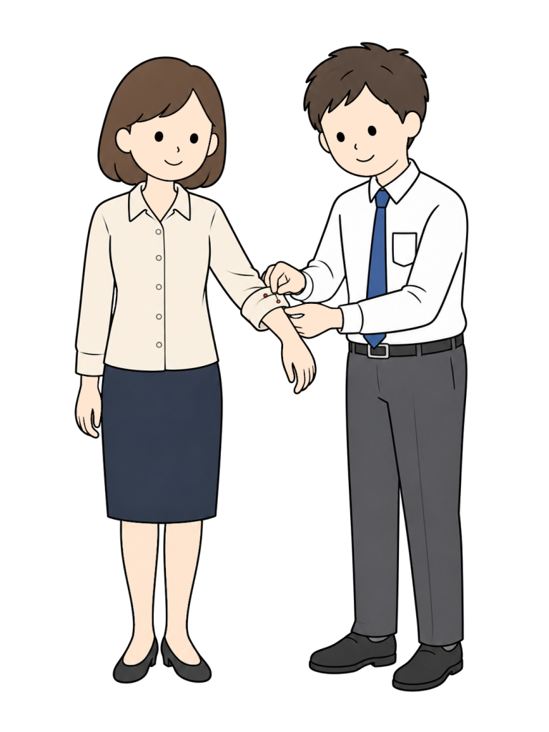 男性の仕立てスタッフが、女性の着用したシャツの袖口を折り返してまち針で留めている。